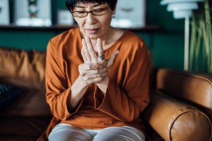 woman holding hand in pain