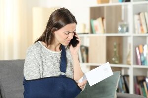 Injured young white female adult looking at claim letter confused