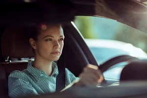 Young, attractive white female looking focused while driving