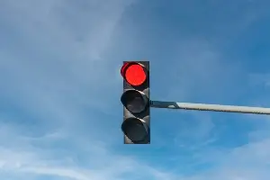 Red light traffic signal on a blue sky background